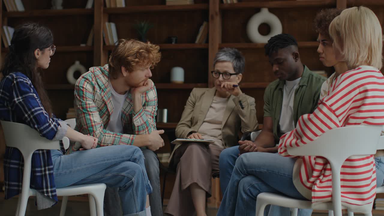 A facilitator and a small group seated in a circle during a group counselling session
