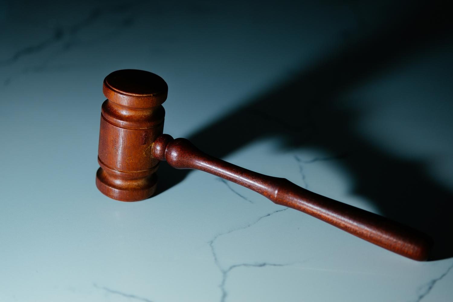A wooden gavel resting on a marble surface