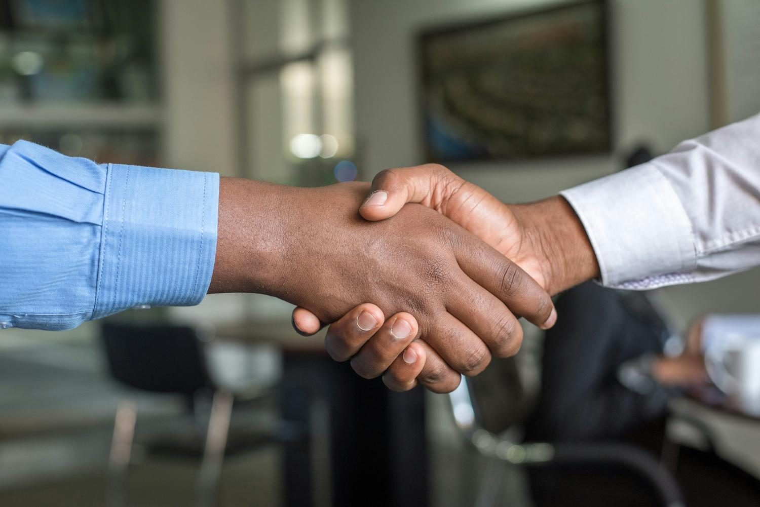 Two professionals shaking hands across a table